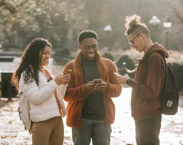 Teenagers on their phones having a laugh outside