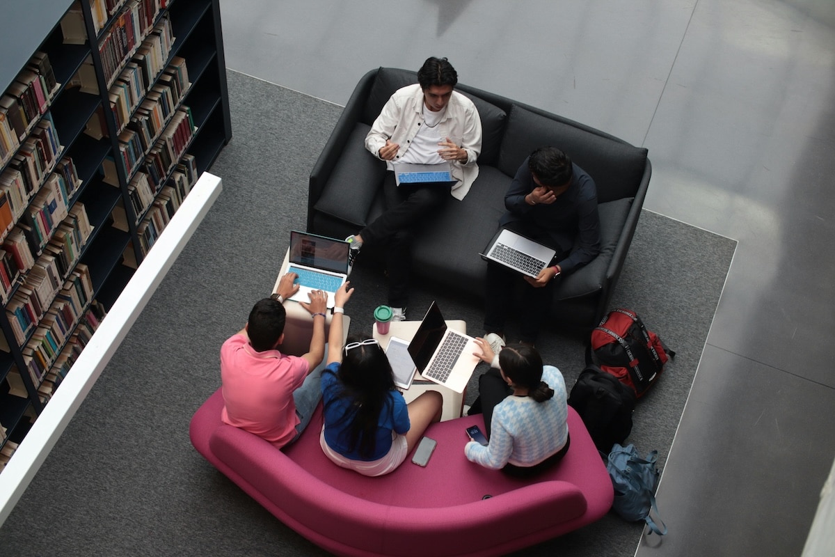 Collaborative Study Session in a Contemporary Library Setting Group of university students studying together on colorful sofas in a modern library
