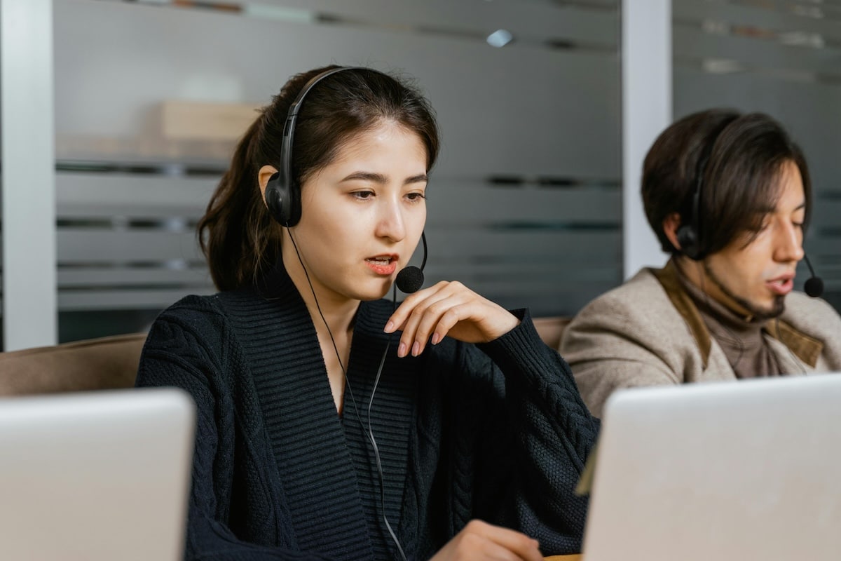 Customer support representatives working at their computers with headsets on