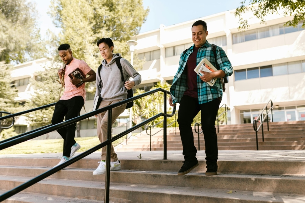 Three college students walking down steps.