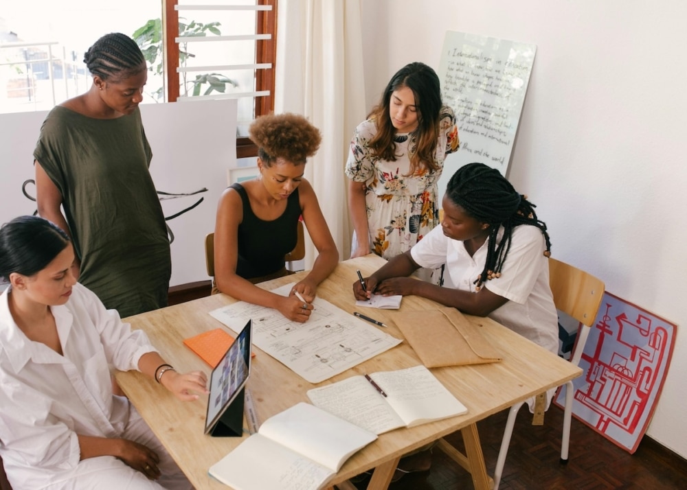Diverse group of women collaborating around a table in a bright office space