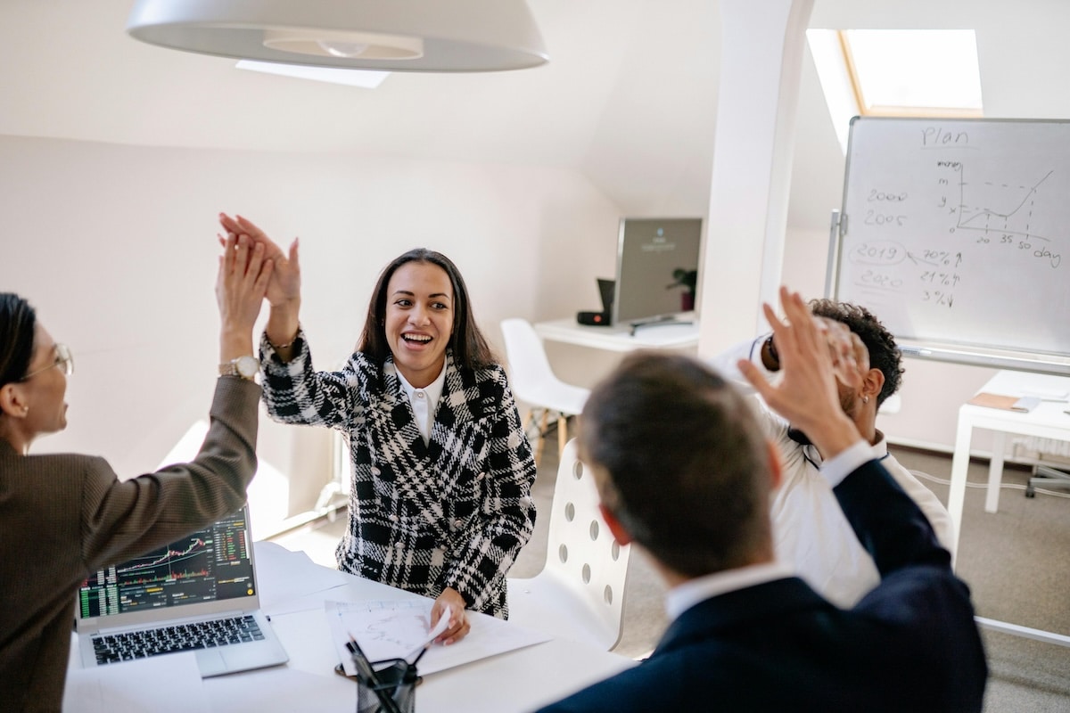 Diverse business team giving high fives during a meeting in a bright modern office